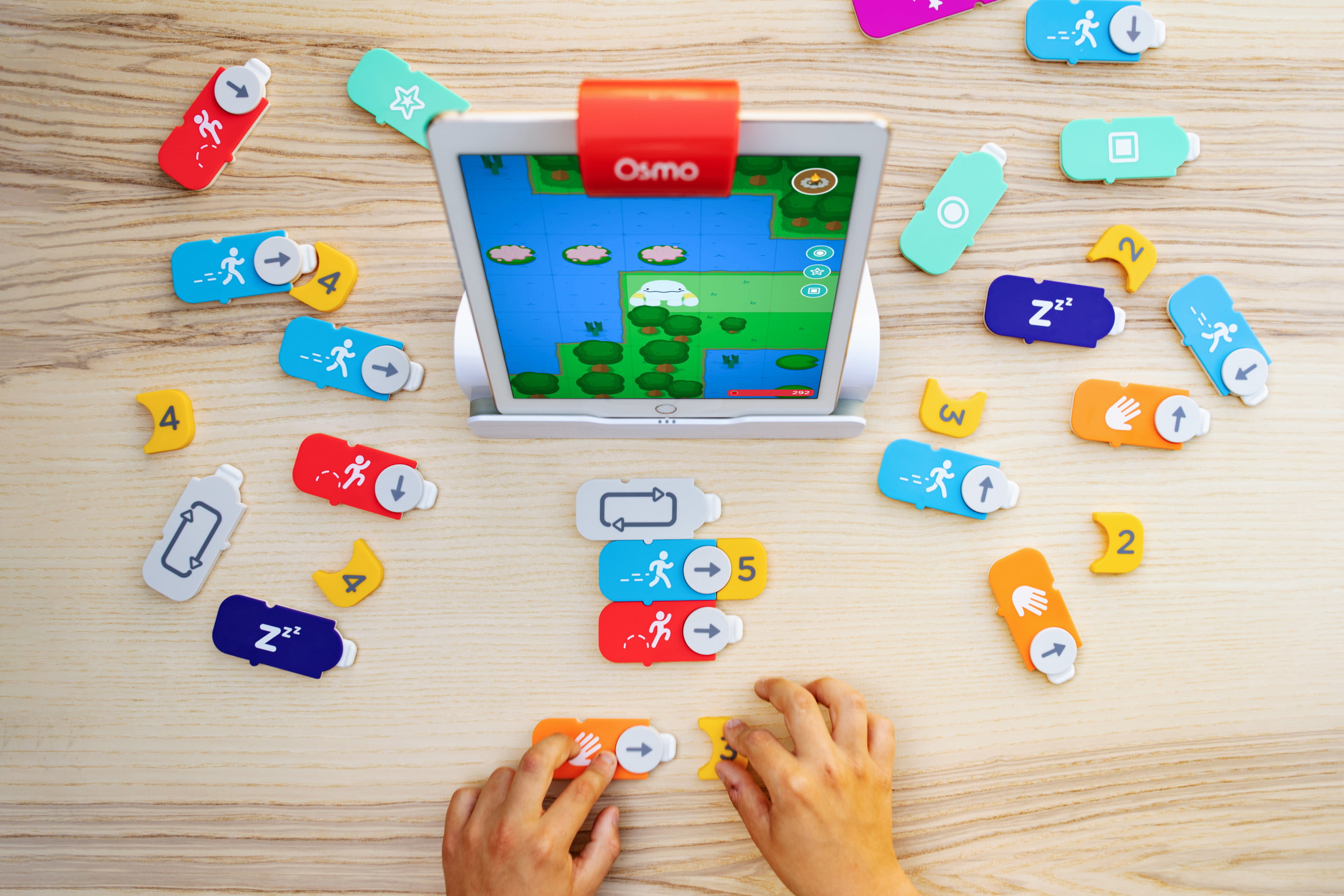 A kid making a program with Osmo coding blocks